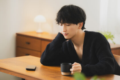 スマホを見つめる男性（オンラインカウンセリング）