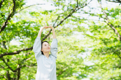 木の下でストレッチをする若い女性　ライフスタイルイメージ