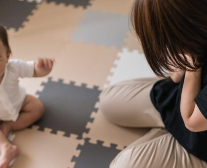 育児に悩み頭を抱える女性（母親と子ども）
